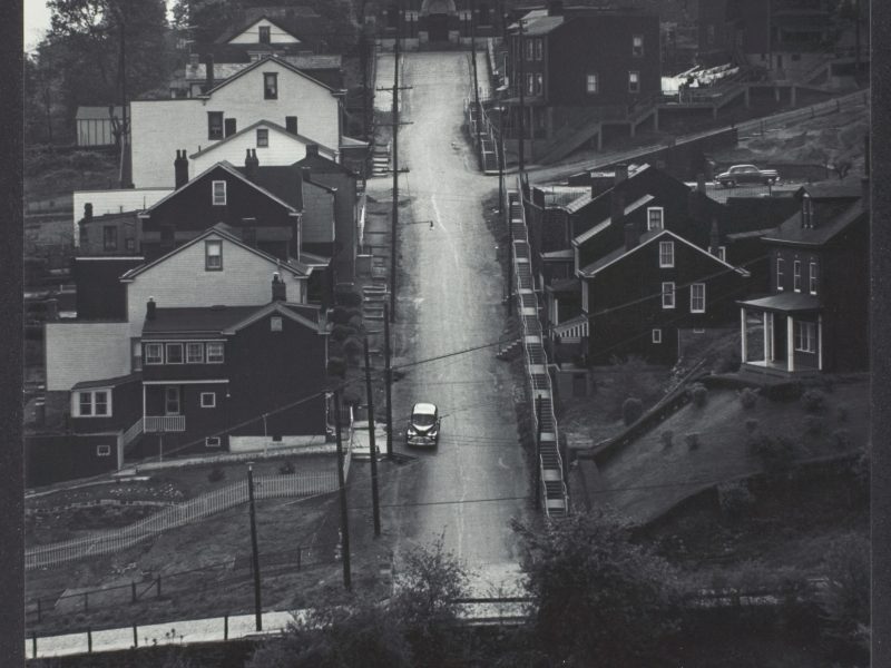 W. Eugene Smith, Street in Pittsburgh: Downhill; houses on either side; church at end of street, 1955